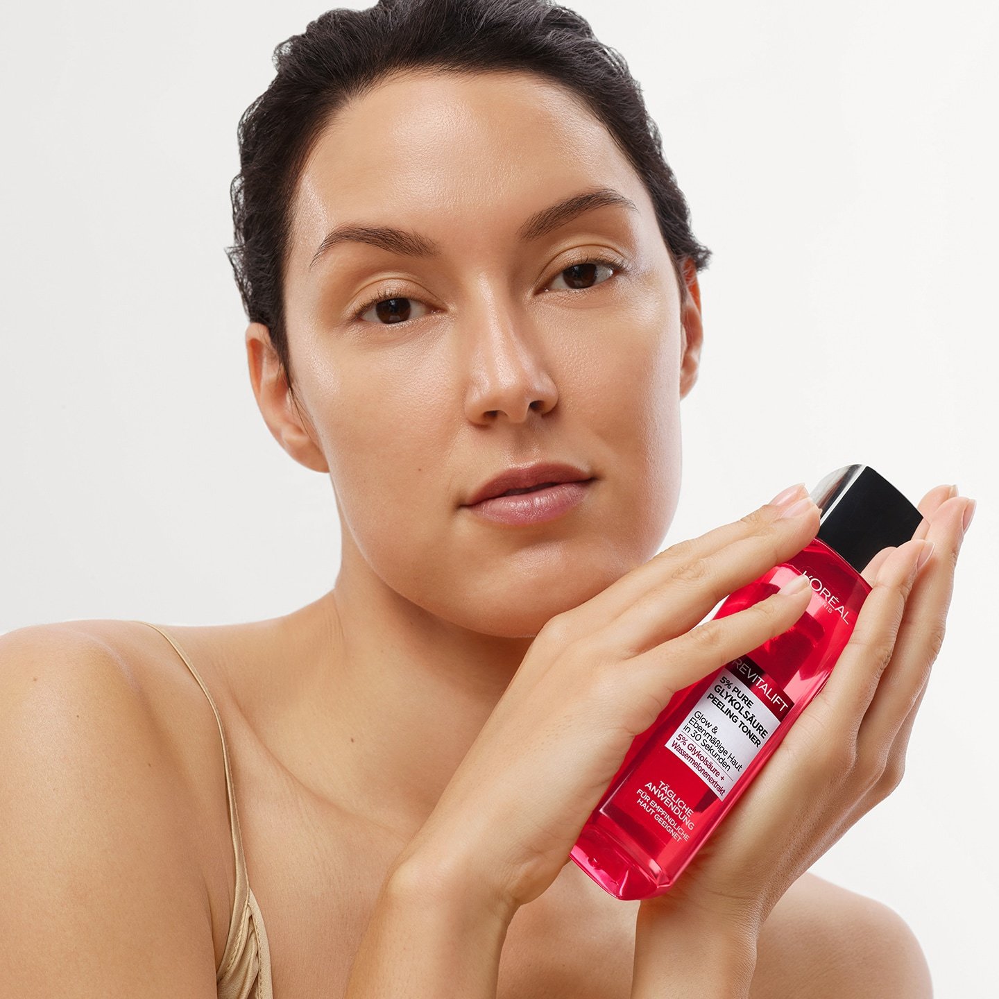 Frau hält Revitalift Peeling Toner in den Händen