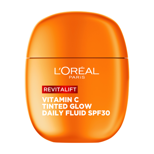 Eine Frau hält das orangefarbene L'Oréal Revitalift Daily Fluid vor ihr Auge und lächelt.