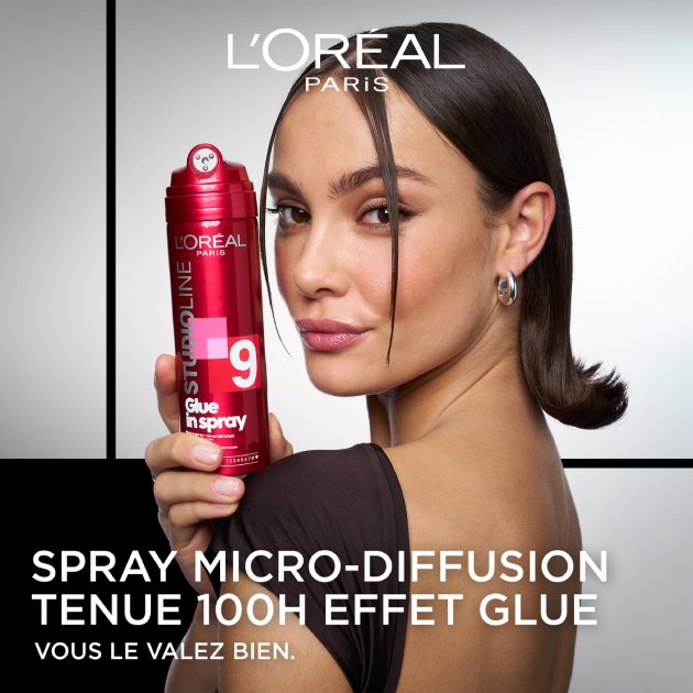 Eine Frau hält das rote Glue in Spray Haarspray in der Hand.