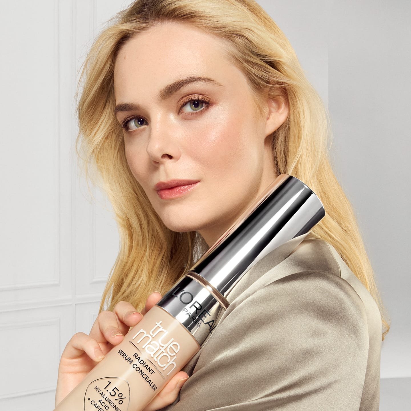 Eine junge Frau mit blonden Haaren, die den Concealer 1.5N Light in ihrer Hand hält