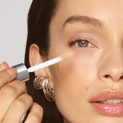 Luma Grothe trägt mit dem Concealerpinsel den Radiant Serum Concealer 7N Medium auf ihre Wange auf