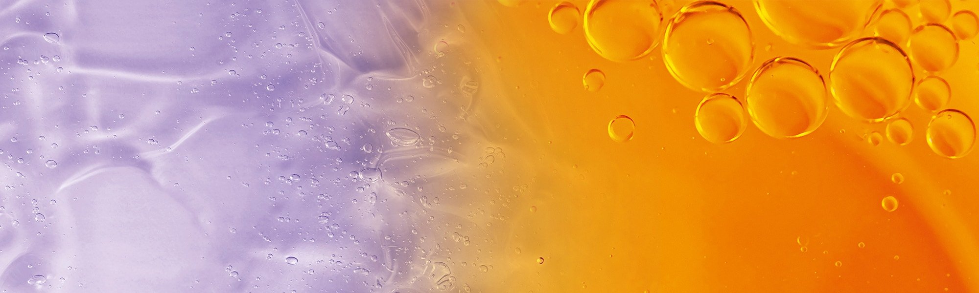 Flüssigkeitstropfen vor violettem und orangenem Hintergrund