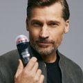 Blonder Mann hält einen Deo Roll-on