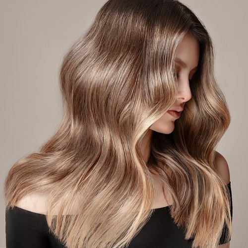 Model mit blondem welligen Haar schaut zur Seite