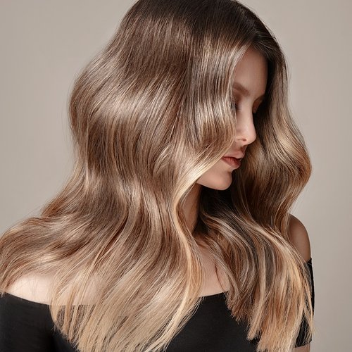 Model mit blondem welligen Haar schaut zur Seite