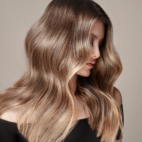 Model mit blondem welligen Haar schaut zur Seite
