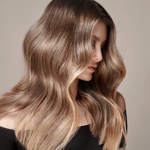 Model mit blondem welligen Haar schaut zur Seite