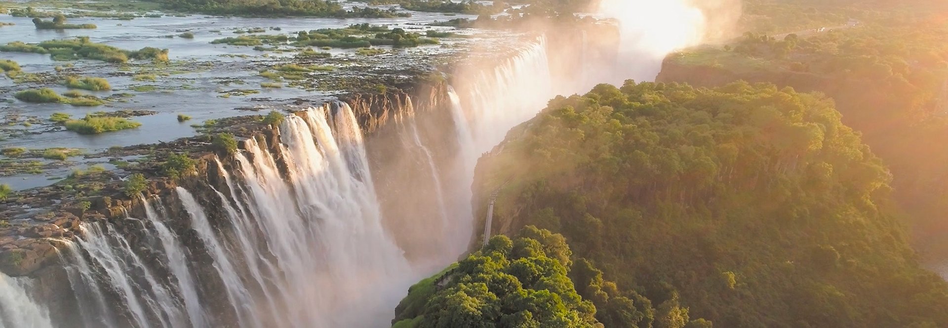 Wasserfall am Rand eines bewaldeten Berges